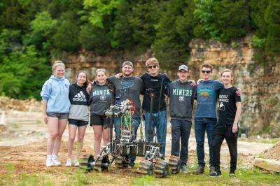 Group of students around robot rover